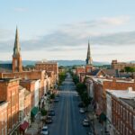 Downtown Hagerstown, Maryland cityscape showing historic buildings and church steeples with mountain foothills in the background under morning sky